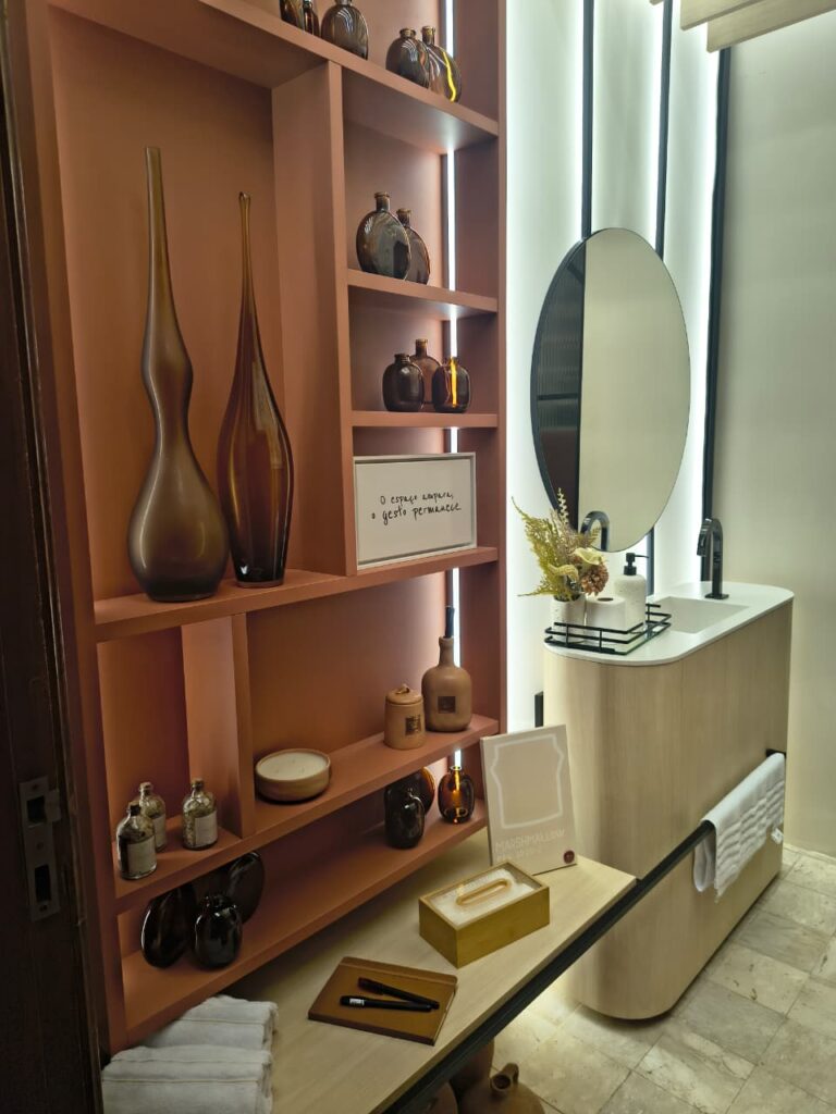 Lavabo com estante em tom terroso e vasos na cor âmbar