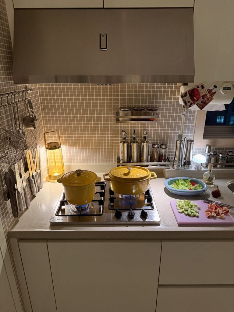 Móveis sob medida com puxadores cava na cozinha com fogão e preparo de jantar