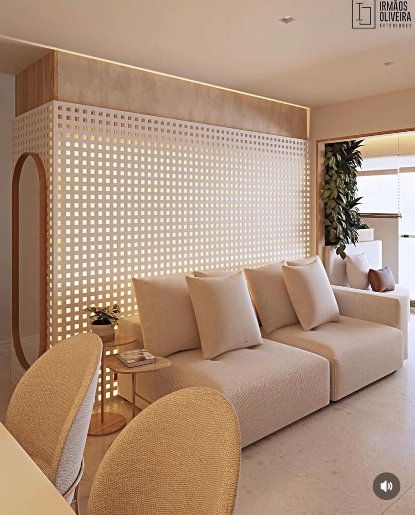 Sala de estar com sofá claro e painel de muxarabi branco atrás