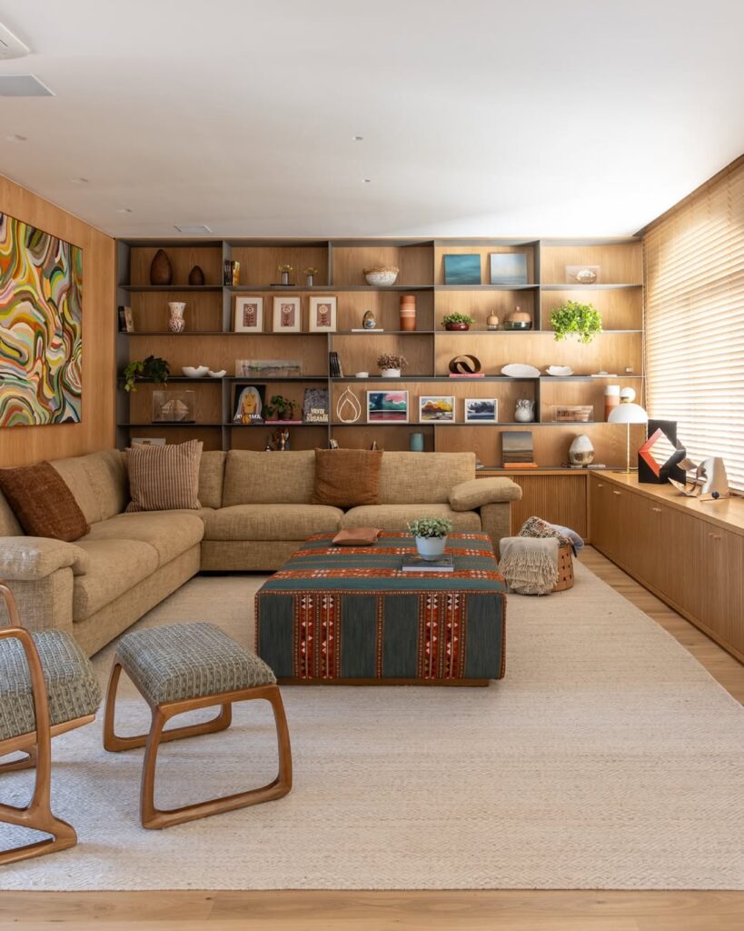 Sala em tons de bege e marrom, com sofá grande e sofá em L