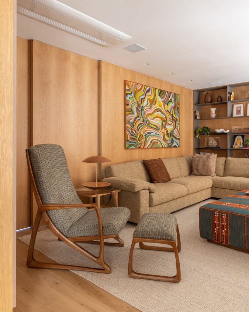 Sala com sofá em L e poltrona com peseira