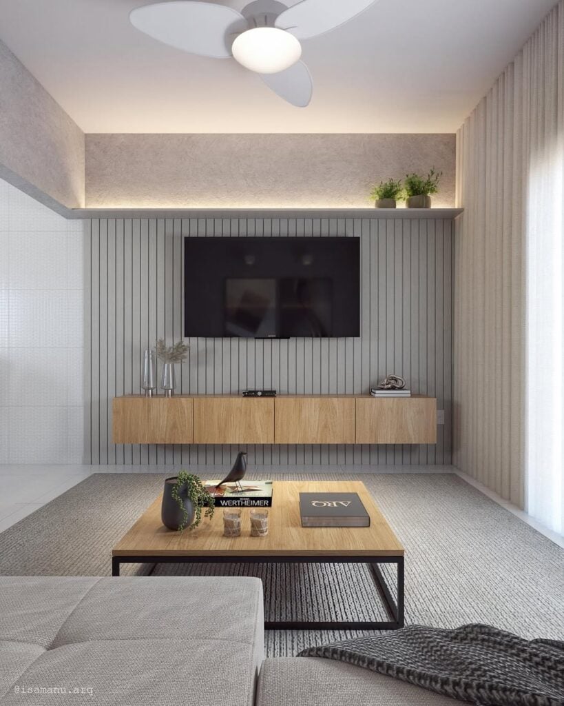 Sala com painel ripado cinza atrás da tv e rack suspenso