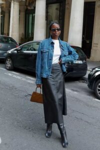Mulher jovem e magra com look com saia de couro longa