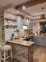 Cozinha estilo farmhouse com bancada americana, armários em cinza claro e detalhes em metal pretos
