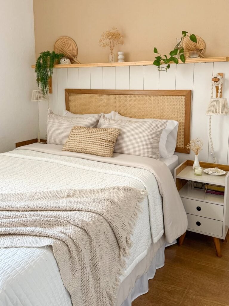 Quarto com meia parede de lambri branco, prateleira de madeira acima e retângulo de palhinha na cabeceira