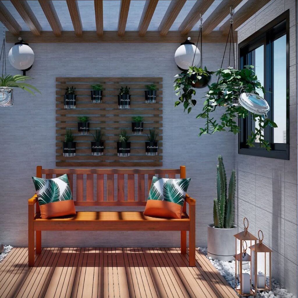 Jardim de inverno com banco de madeira e almofadas, estrado de madeira com vasos na parede, cactus no canto e lanternas decorativas