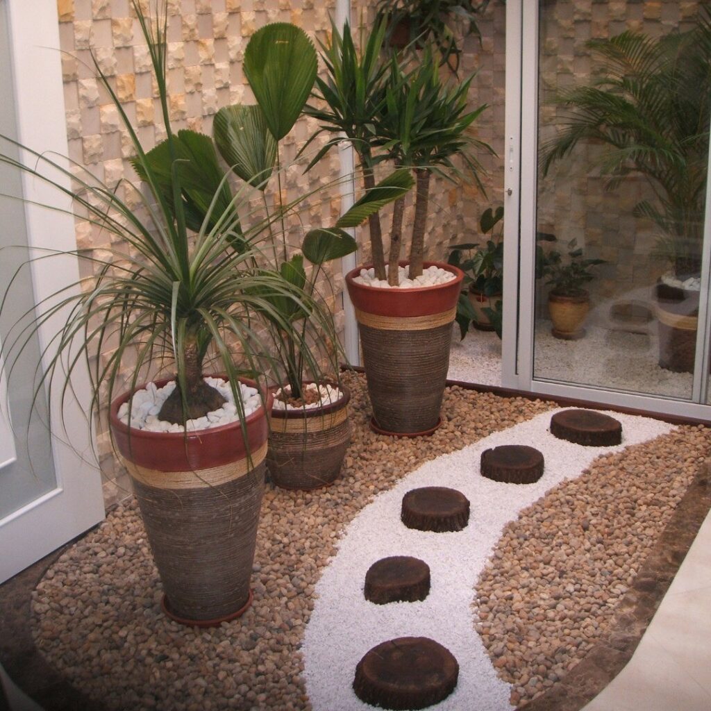 Jardim de inverno com seixos, pedras brancas e vasos grandes com plantas