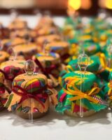Vidros pequenos com doces e paninhos coloridos na tampa com laço e colherzinhas