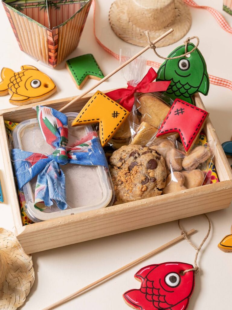 Caixa de madeira com biscoitos em formato de bandeirinhas, cookie e amendoins