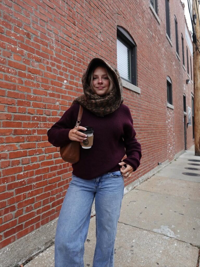 Mulher jovem usando cachecol, suéter e calça jeans