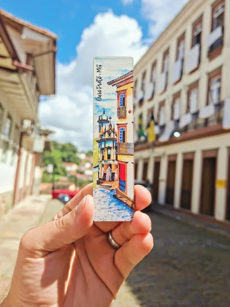 Mão segurando um marca-página de Ouro Preto