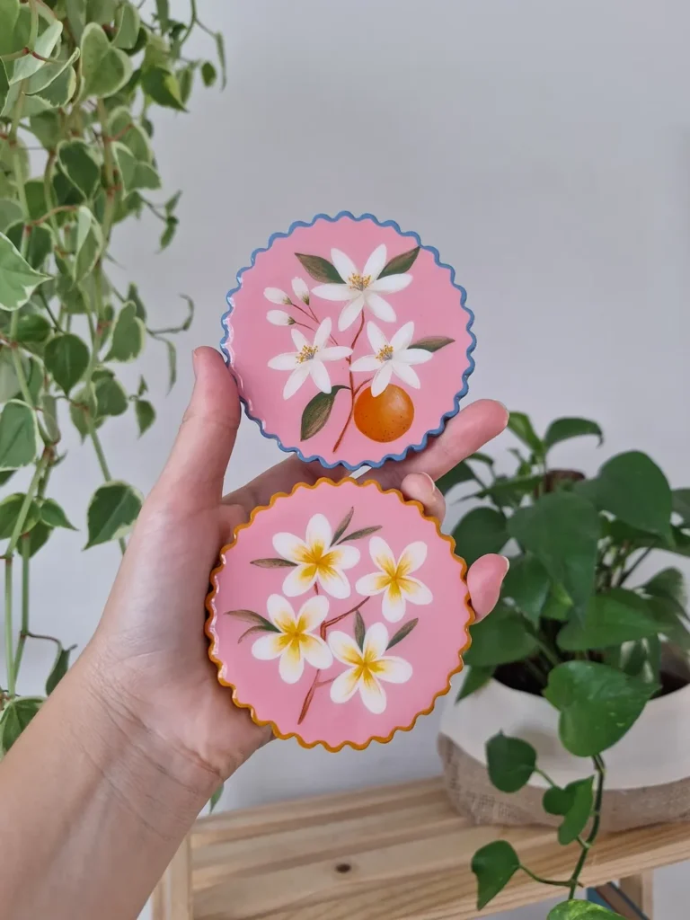 Itens decorativos de cerâmica fria com fundo rosa e flores brancas