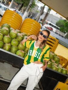 Mulher jovem com camiseta do brasil verde e amarela e calça branca