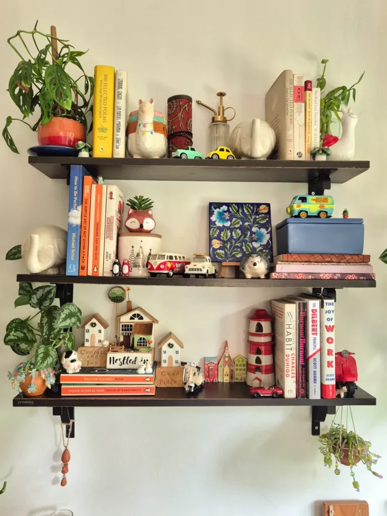 Estante com prateleiras escuras e vários objetos decorativos pequenos