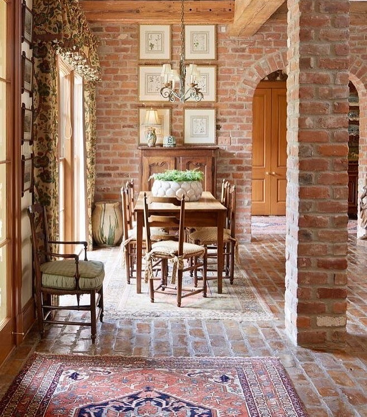 Casa com tijolinhos à vista, sala de jantar com quadros na parede