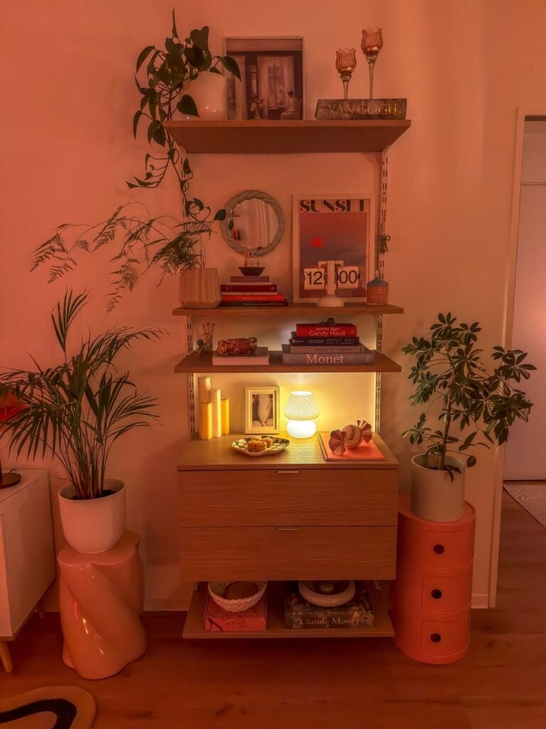 Estante com prateleiras e gavetas, livros, luminária e outros objetos