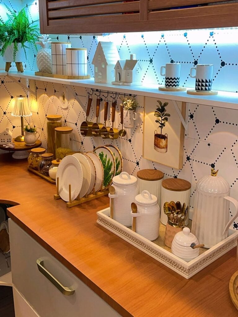 Bancada de cozinha de madeira, com louças e itens decorativos em tons neutros