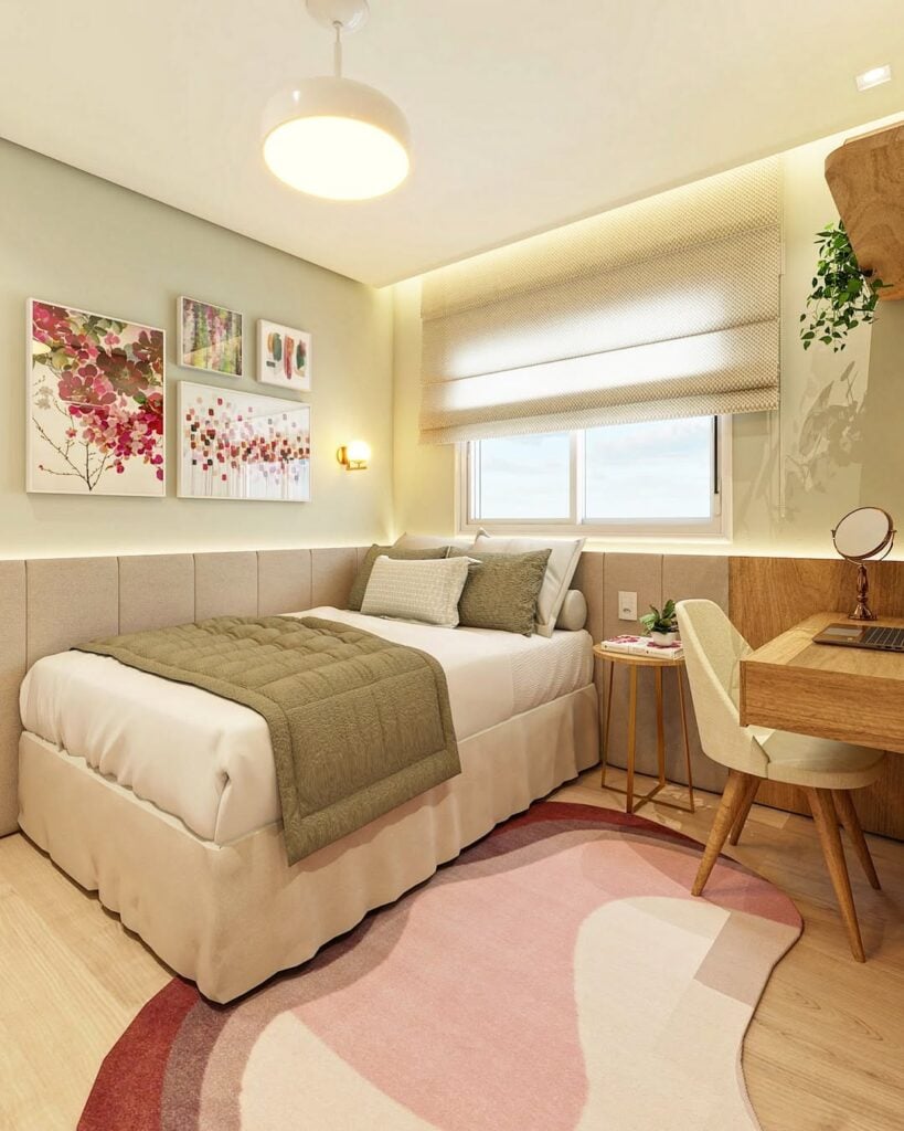 Quarto com quadros na parede lateral da cama, escrivaninha e tapete orgânicos em tons rosados