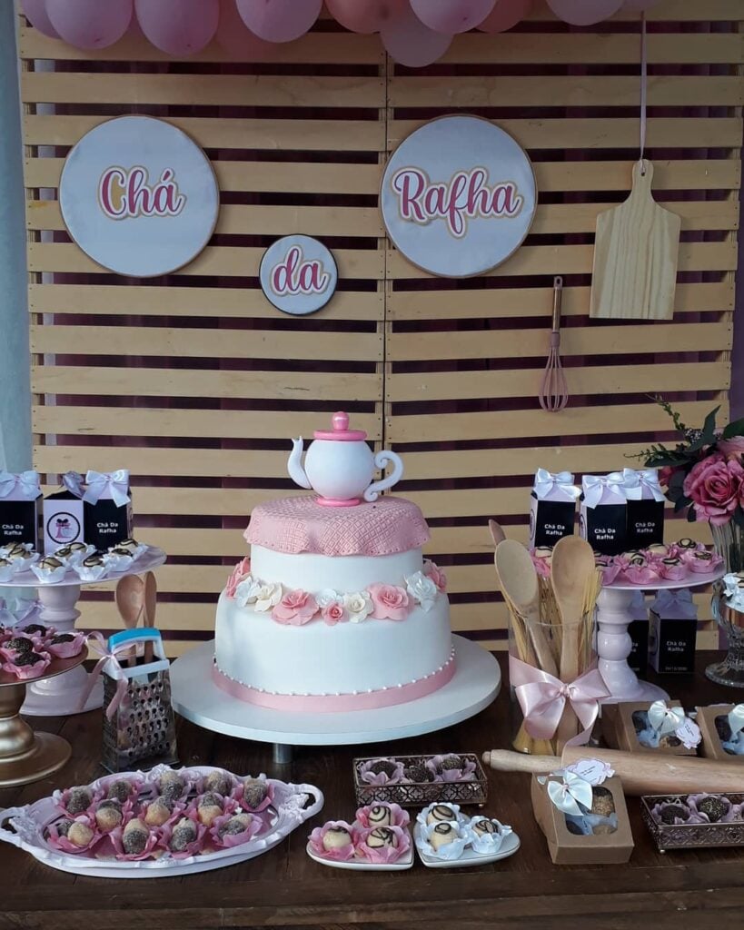 Decoração de chá de cozinha com colheres de pau, ralador e docinhos na mesa