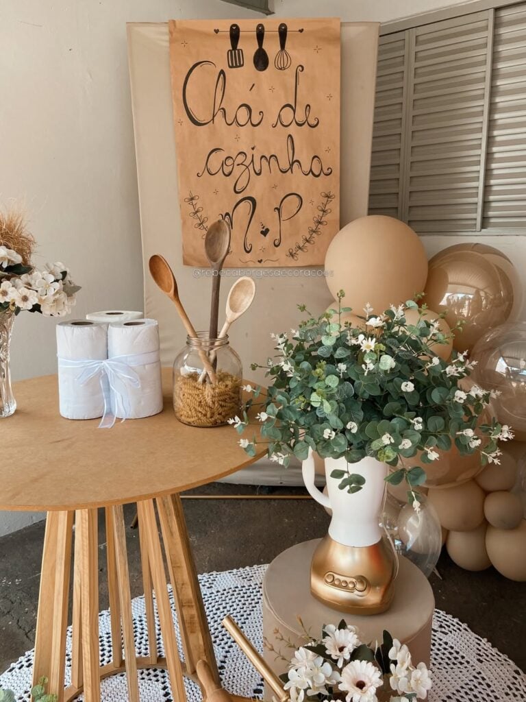 Decoração de chá de cozinha com mesa de MDF, colheres de pau e planta em liquidificador