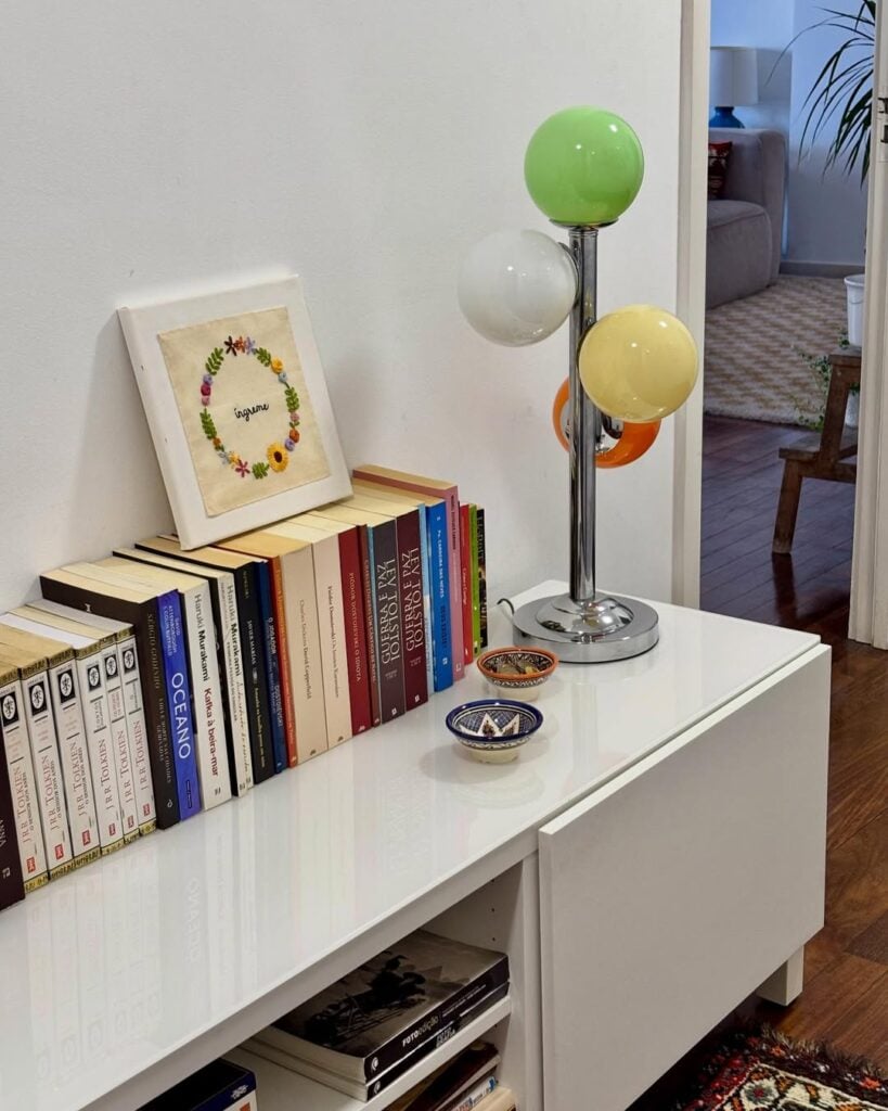 Balcão baixo branco com libros empilhados na vertical