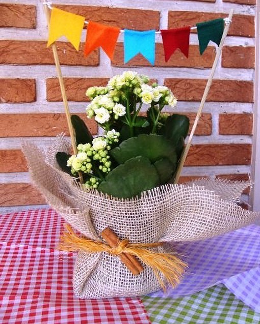 Vasinho de flores envolvido em juta com pau de canela e palitos com bandeirinhas