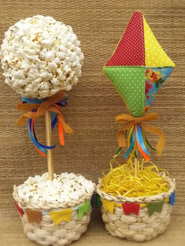 Enfeites de São João para mesa com base de palha e palitos com pipoca e balão de tecidos coloridos
