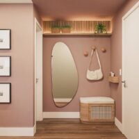 Hall de apartamento com a parede rosa, espelho orgãnico, banco e suporte para bolsas