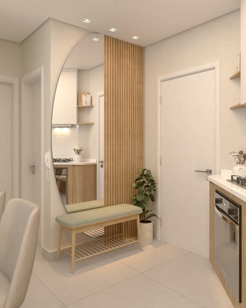 Hall de entrada de apartamento com painel ripado, vaso de planta, banco e espelho meio circular