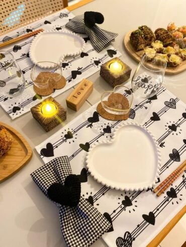 Mesa posta de Dia dos Namorados com jogo americano branco com corações pretos, guardanapos xadrez preto e branco