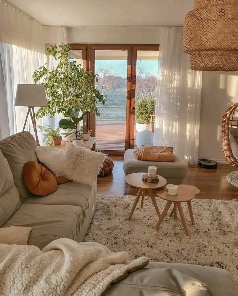 Sala de estar com sofá cinza-claro, tapete felpudo, almofadas e luminária de fibras naturais