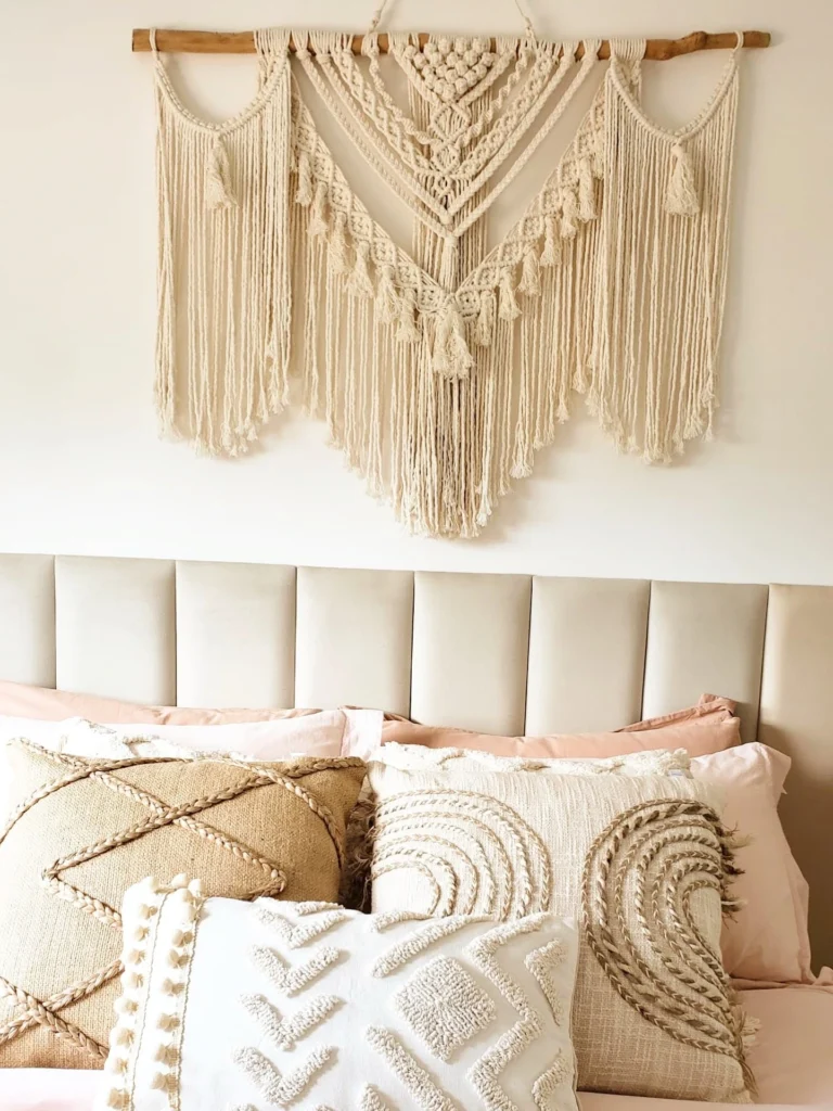 Quarto com cabeceira modular, almofadas e macramê na parede