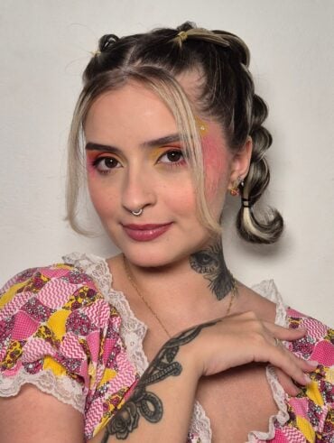 Mulher de pele clara, com maquiagem colorida e penteado de São João