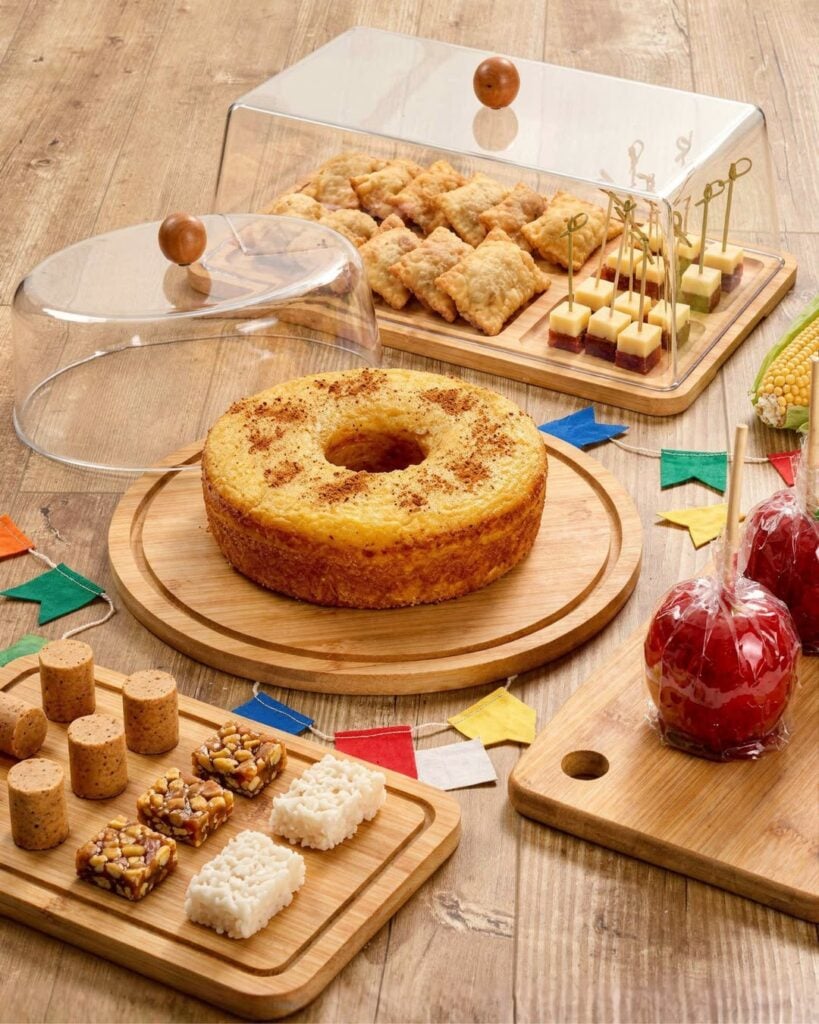 Mesa de São João com maçã do amor, bolo com amendoim, paçocas, cocadas e rapaduras