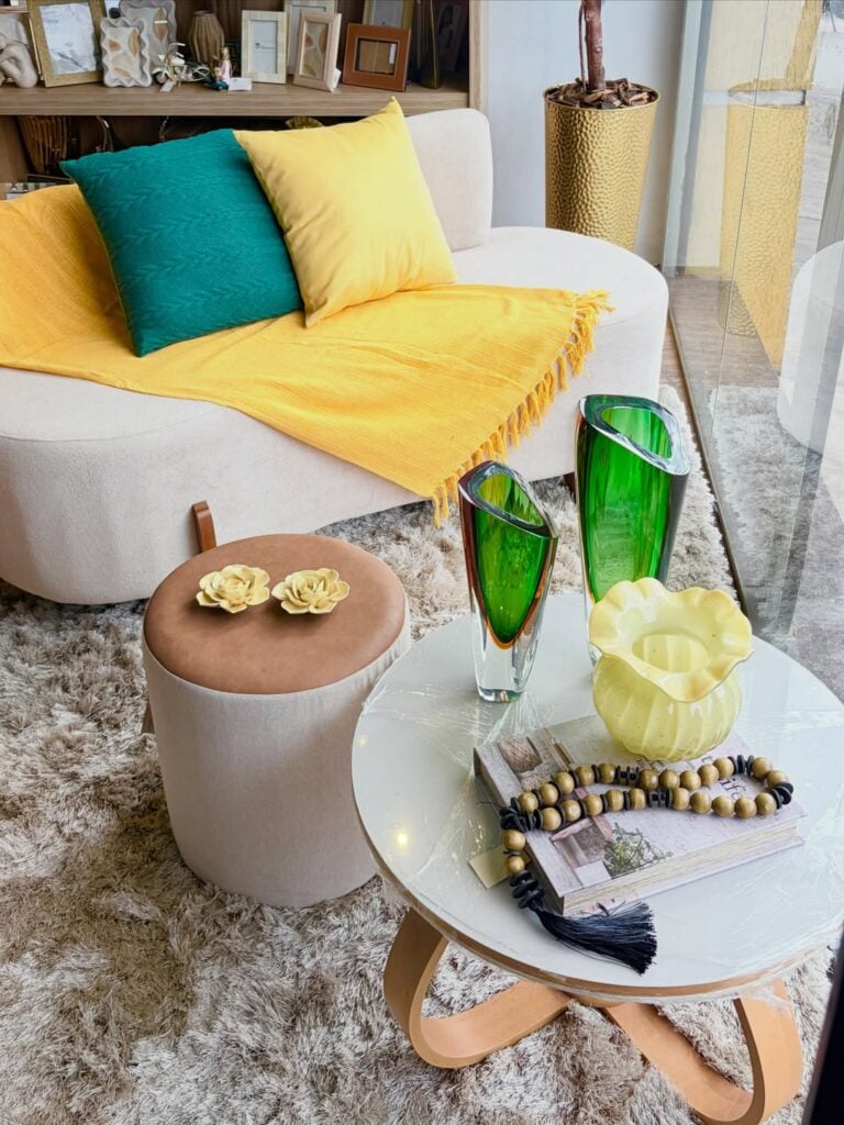Sala para Copa com sofá curvo branco com manta amarela e almofadas em verde e amarelo
