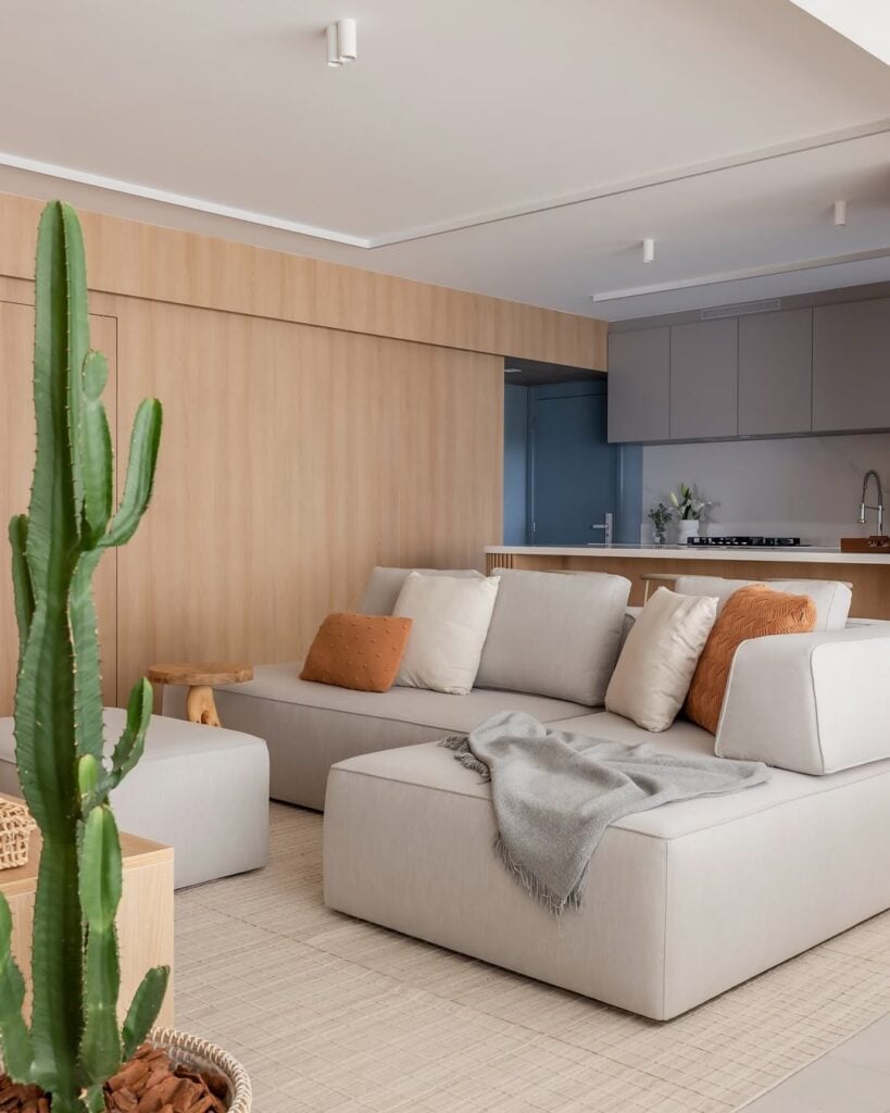 Sala com sofá modular, manta e almofadas