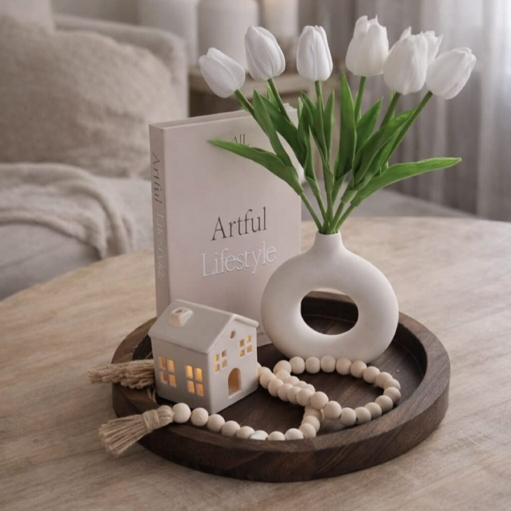 Bandeja decorativa de madeira escura com vaso e tulipas brancas, enfeites e livro