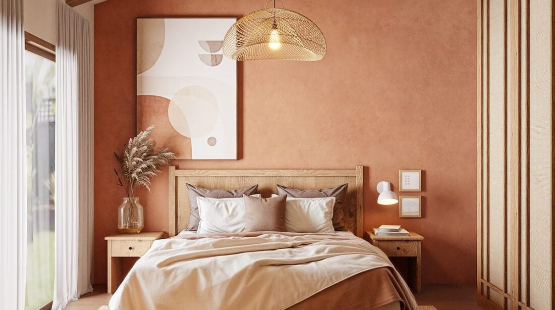 Quarto em tons terrosos na parede, quadro e roupa de cama, e madeira aparente