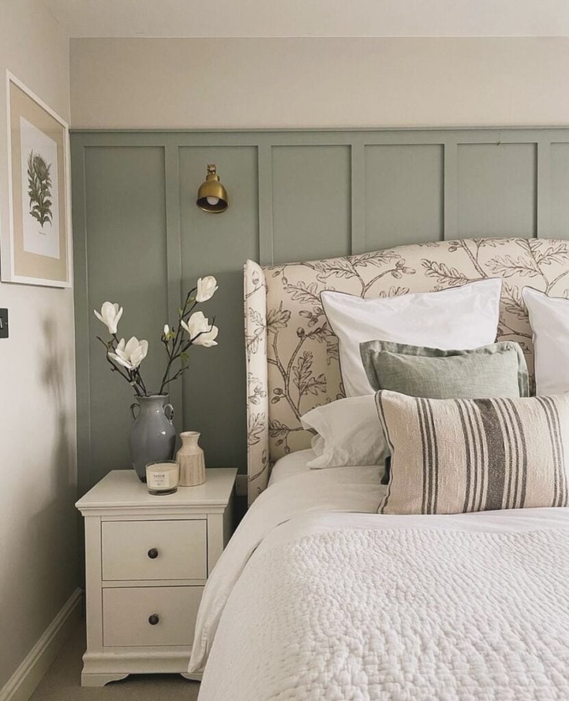 Quarto em tons neutros de branco, bege e cinza com cabeceira floral e mesa de cabeceira branca com gavetas