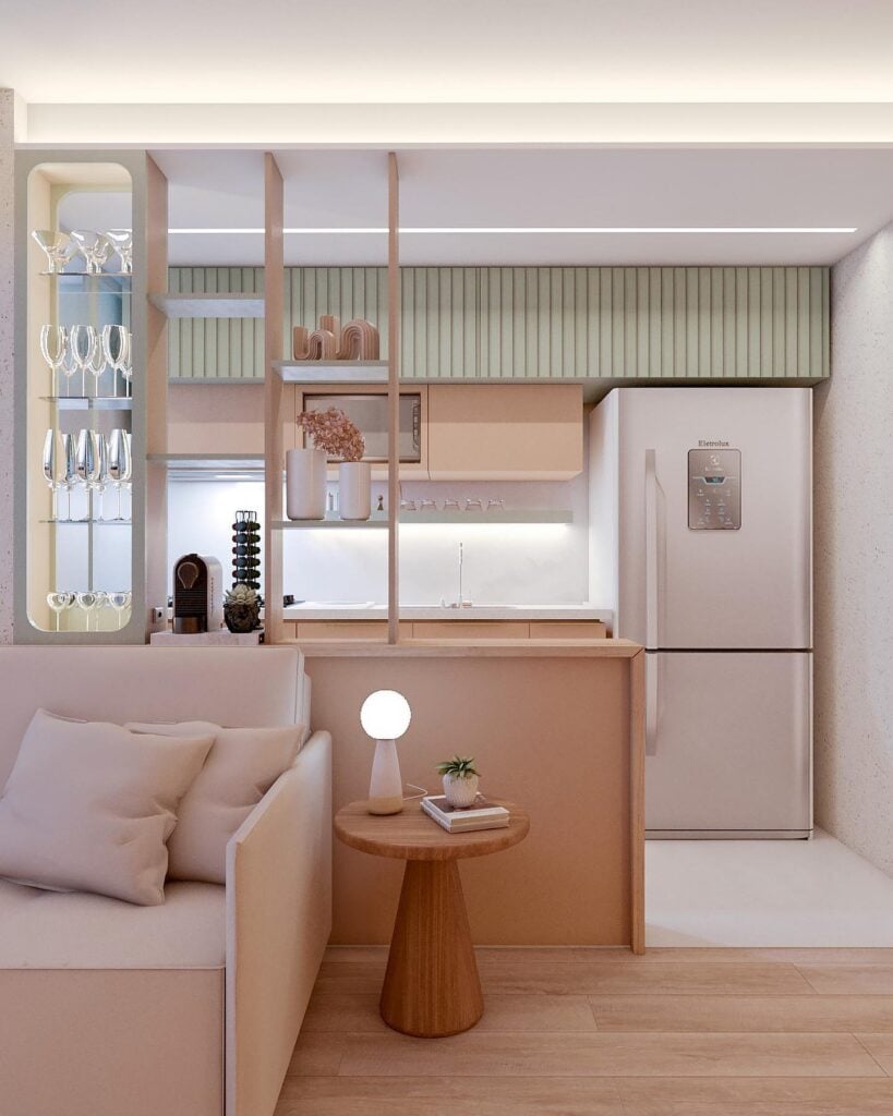 Sala e cozinha em tons de rosa e verde-claro e detalhes amadeirados