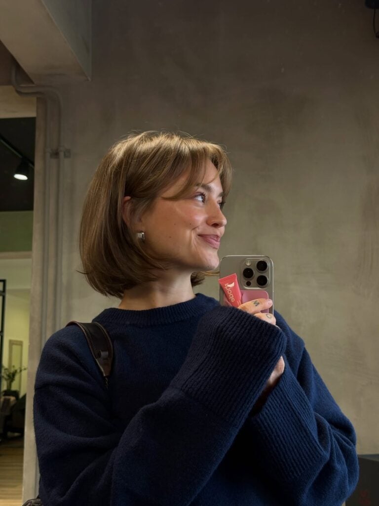 Mulher de pele clara, com cabelo loiro curto 