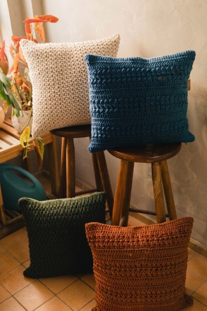 Almofadas em tricô bege, azul, verde e terracota