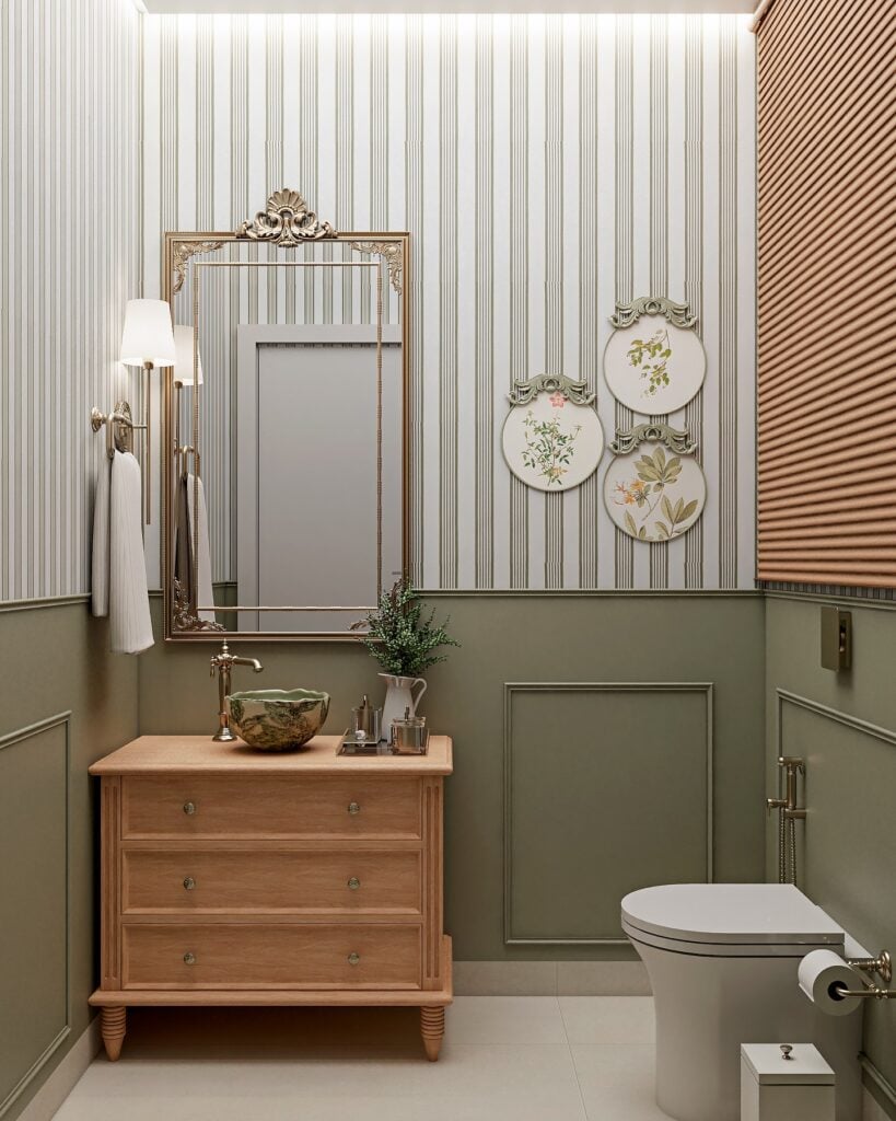 Lavabo pequeno com meia parede verde com boiserie, papel de parede listrado, bancada de madeira com gavetas e cuba de apoio