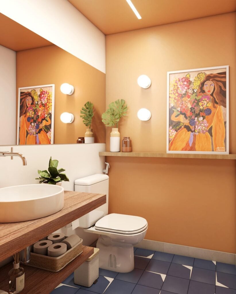 Lavabo pequeno com bancada de madeia, cuba e louças brancas, arandelas e quadro colorido