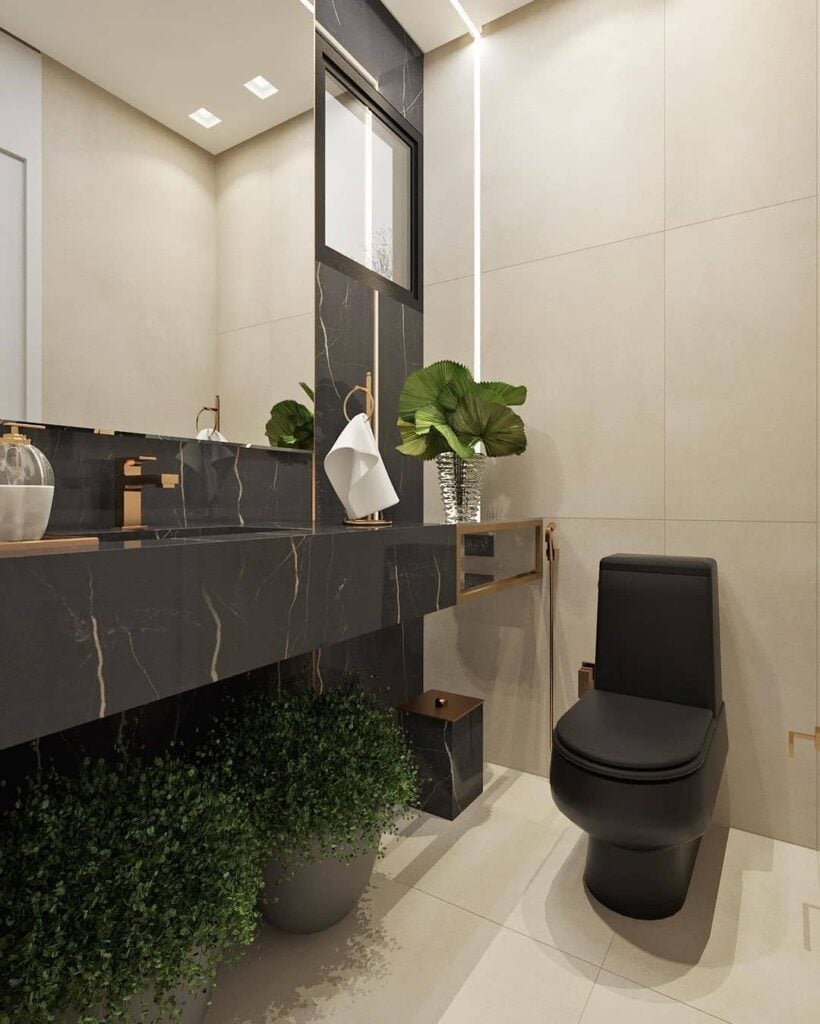 Lavabo com revestimentos claros, bancada e utensílios em preto fosco com metais dourados, e plantas
