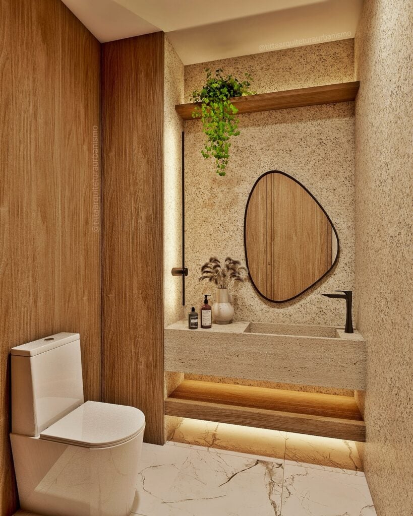 Lavabo pequeno com painel amadeirado, bancada suspensa com cuba embutida, espelho orgânico com borda preta