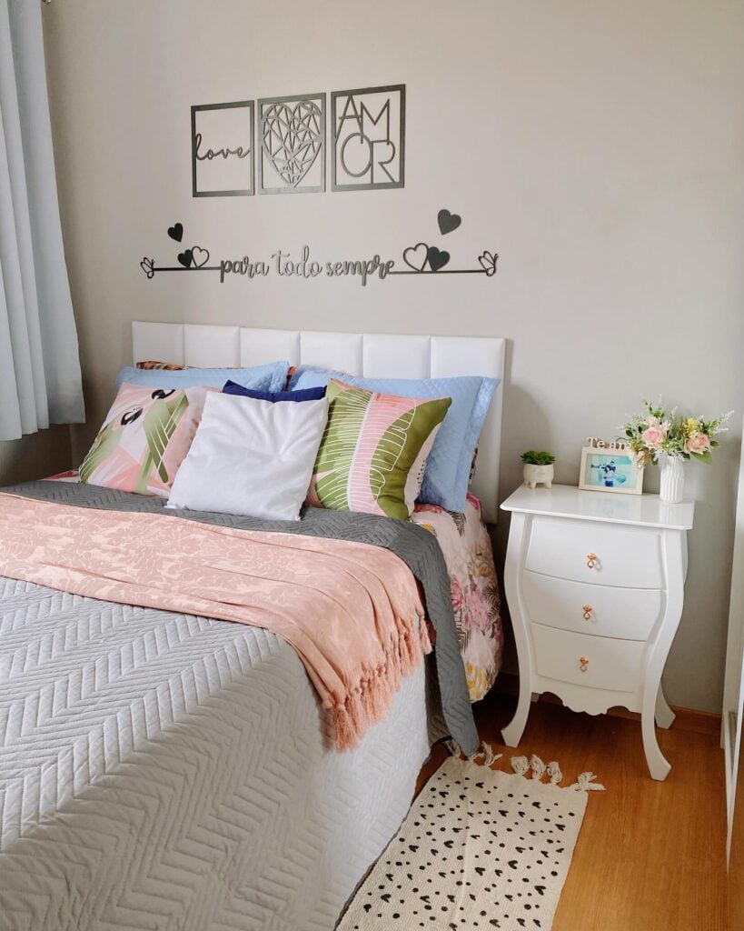 Quarto com cabeceira estofada branca e mesa de cabeceira branca com pés torneados