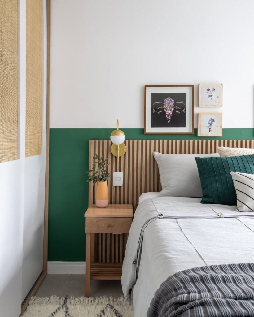 Quarto com cabeceira ripada e mesa de cabeceira de madeira com vasinho e planta