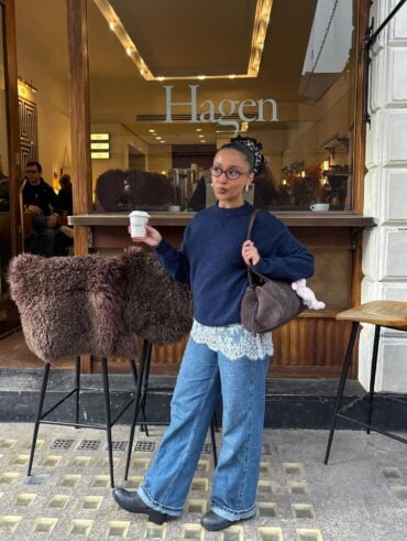 Mulher jovem com look com suéter, saia de renda mini, calça jeans e bota